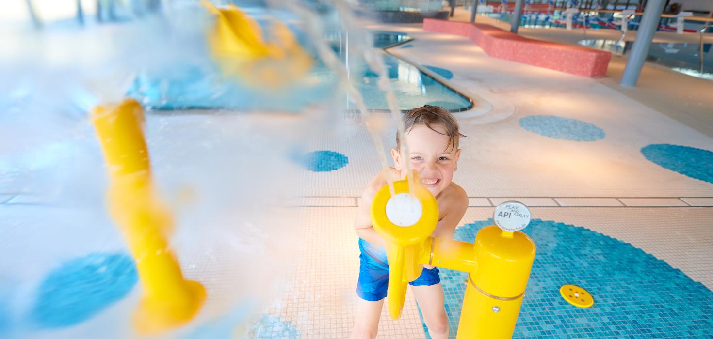 Junge spielt auf dem Wasserspielplatz