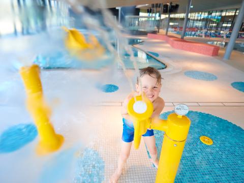 Junge spielt auf dem Wasserspielplatz