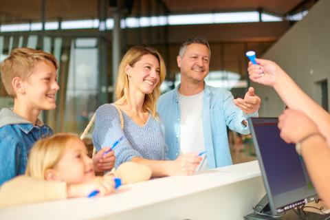 Familie steht an der Kasse des Schwaketenbades und bezahlt.