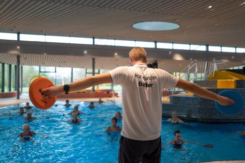 Fitnesstrainer am Beckenrand